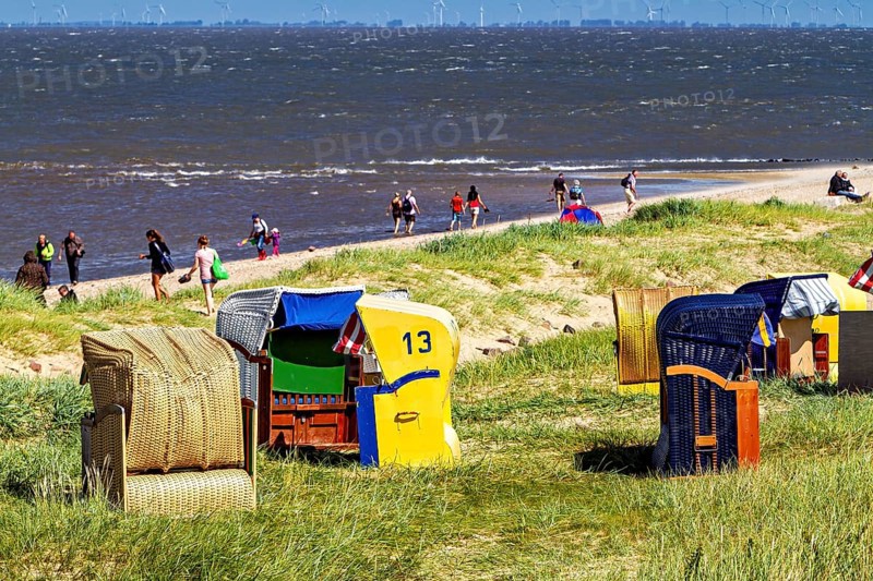People on sandy beach with beach chairs on the coast and sea view, beach chairs on Cuxhaven beach