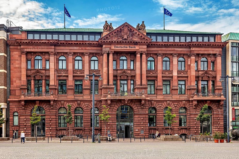 Historic bank building with red façade and two flags on the roof under a blue sky, The center of the Hanseatic City of Bremen