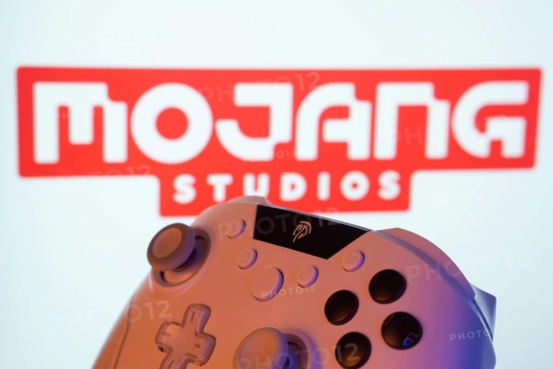 Dhaka, Bangladesh- 20 Mar 2025: A close-up of a white gamepad with the Mojang Studios seen on screen in the background