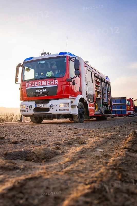 A fire truck stands on a country road in patrol light, firefighters ready to act, fire brigade exercise on the Hermann Hesse Railway, Ostelsheim, Calw district, Germany