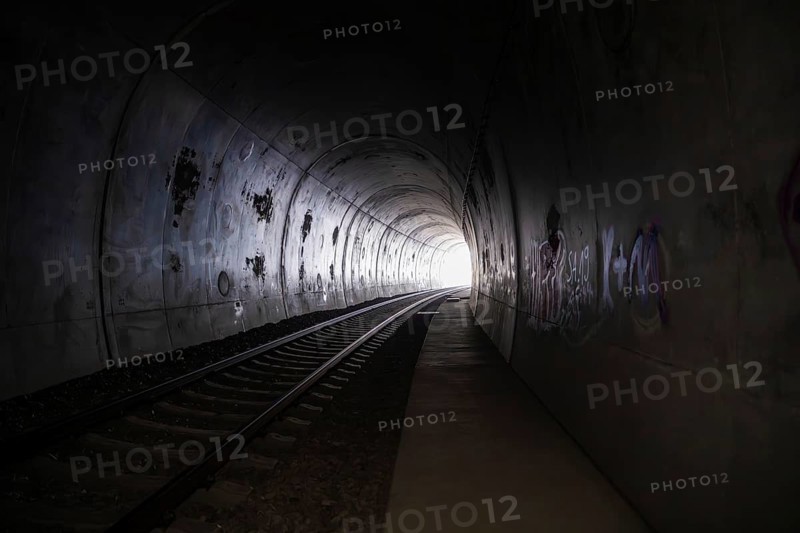 Dark tunnel with railroad tracks, graffiti and a light in the distance, fire brigade exercise on the Hermann Hesse Railway, Ostelsheim, Calw district, Germany