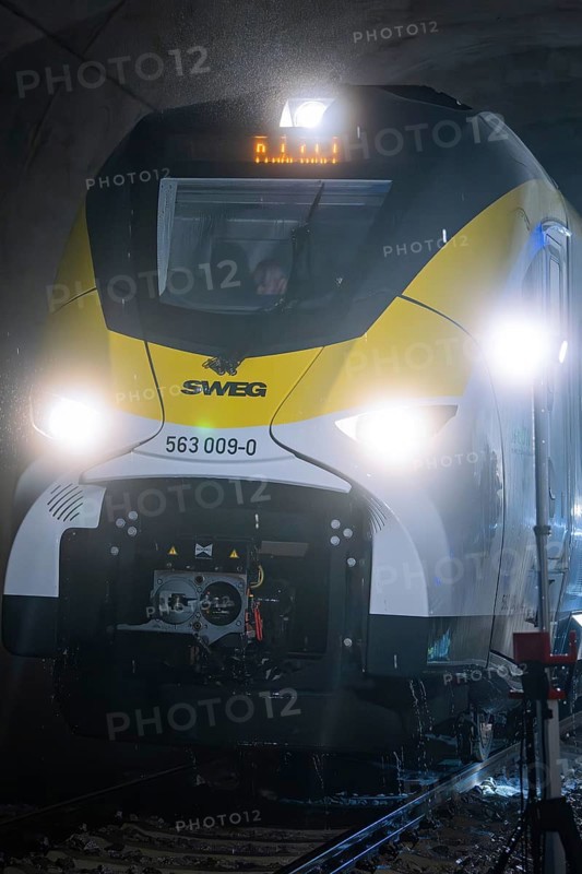 Yellow train travels through an illuminated tunnel on dark tracks, fire department exercise on the Hermann Hesse Railway, Ostelsheim, Germany