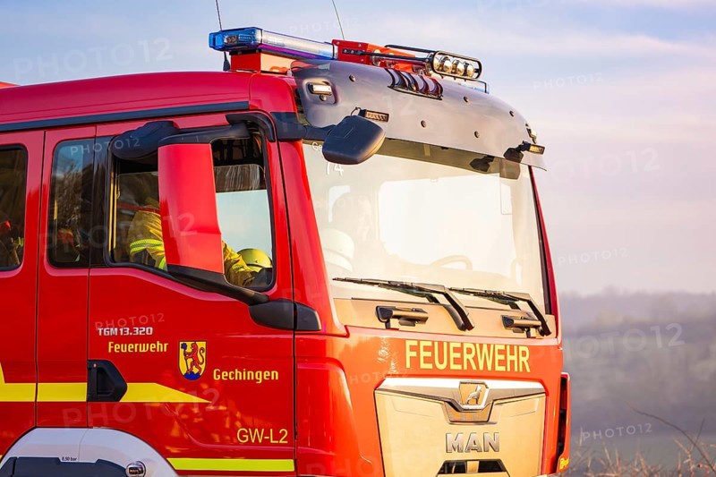 A red fire engine stands outdoors with a view of the countryside, fire department exercise on the Hermann Hesse railway, Ostelsheim, Germany