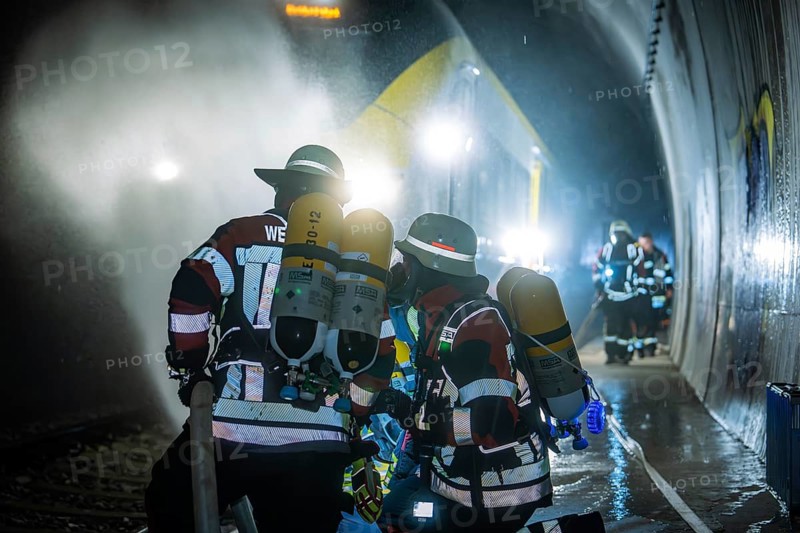 Firefighters working in a gloomy tunnel with respirators, fire brigade exercise on the Hermann Hesse Railway, Ostelsheim, Germany