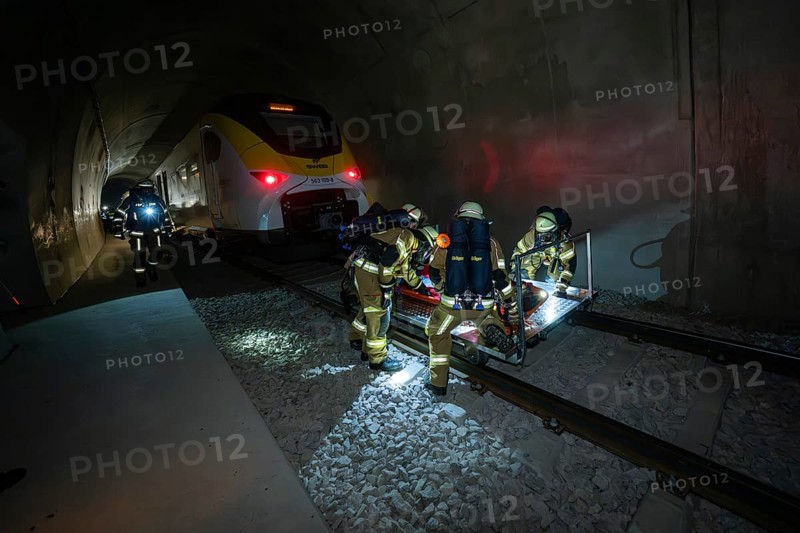 Firefighters rescue a person on the tracks in a tunnel at night, fire brigade exercise on the Hermann Hesse railway, Ostelsheim, Germany