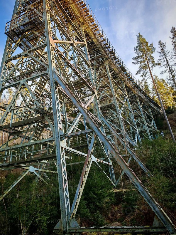 Massive metal structure of an old railroad bridge towering high above a forest, Ziemestalbrücke, Thuringian Forest