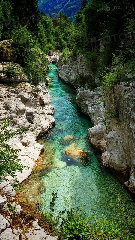 Crystal-clear river flows through a narrow, rock-lined gorge, Soca Valley, Slovenia