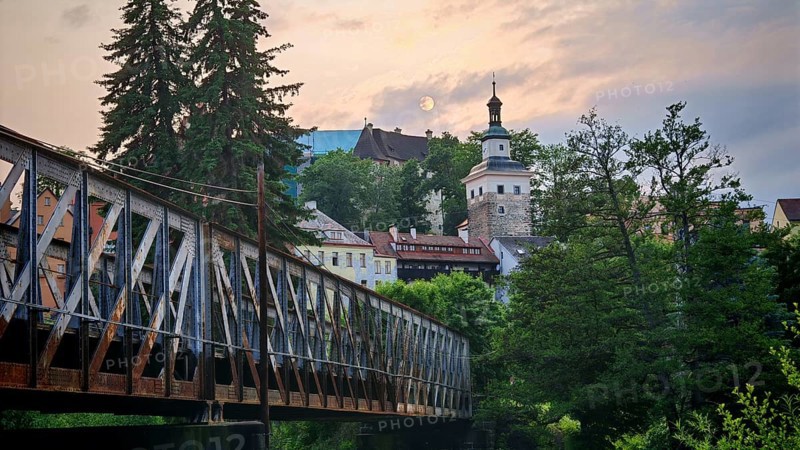 Idyllic city view with old railroad bridge and tower over a river in the evening light, Loket, Czech Republic