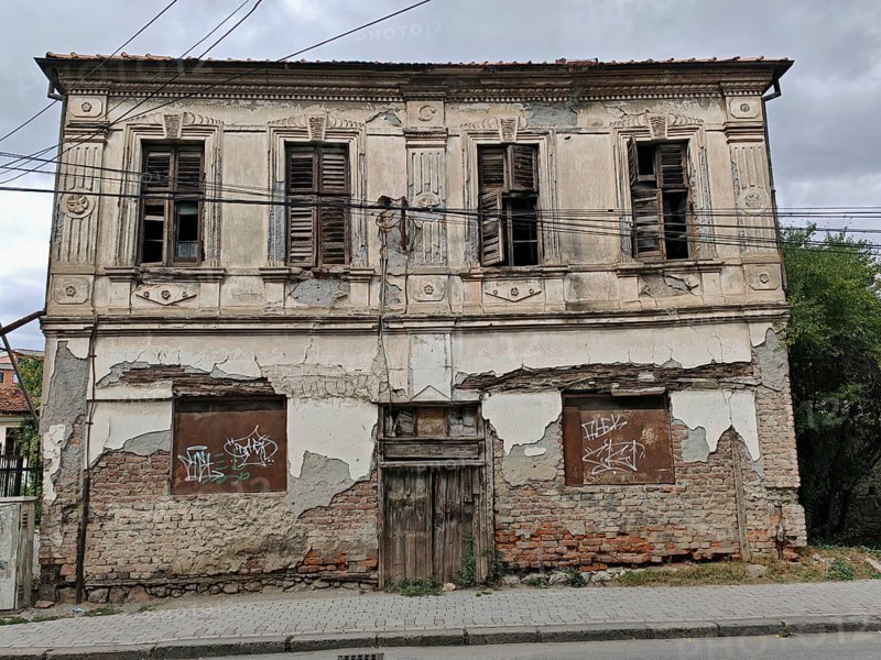 An old, dilapidated building with closed shutters and crumbling façade, Ohrid, North Macedonia