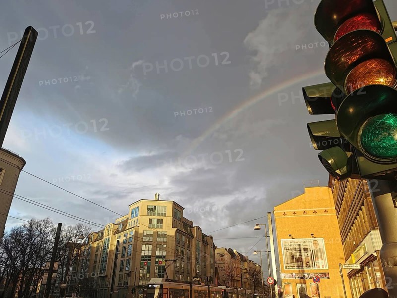Rainbow over urban scene with traffic light and cloudy sky, Berlin