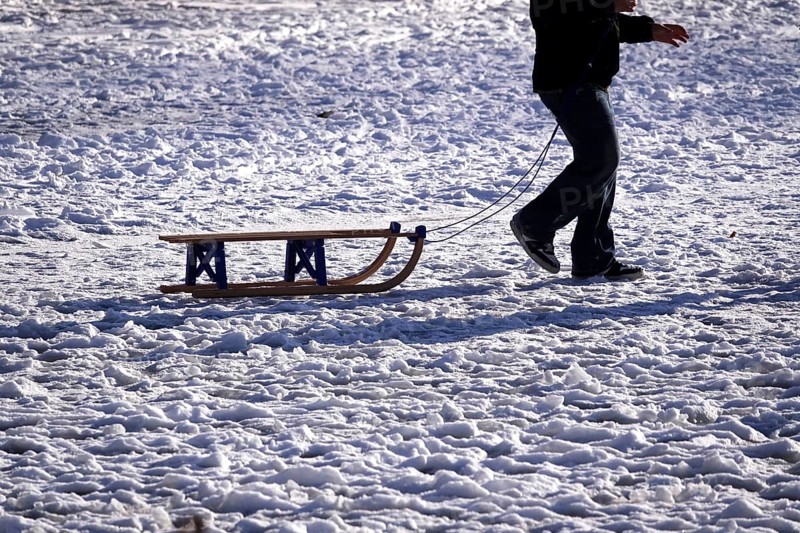 Sled in snow pulled by a man, winter, Germany