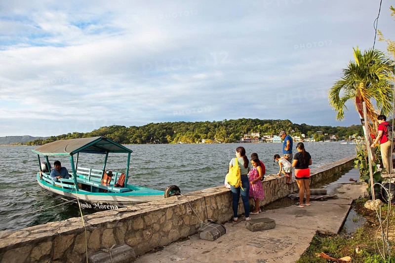 Guatemalans and a boat on the shore, Lake Petén Itzá in Flores, Petén Department, Guatemala