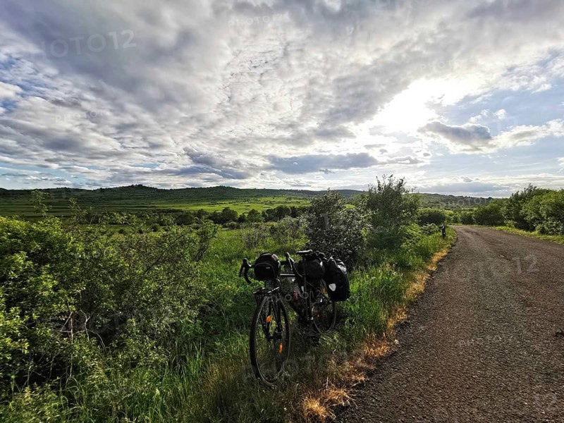 Bicycle along a rural trail with vast green fields and dramatic skies, Czech Republic