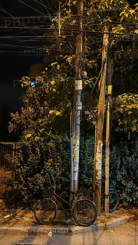 Bicycle leaning against a power pole under a street lamp at night, Montenegro
