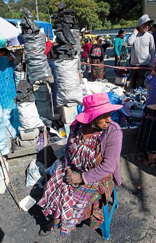 Mayan woman in traditional clothing selling charcoal at the market in Sololá, Highlands, Sololá Department, Guatemala