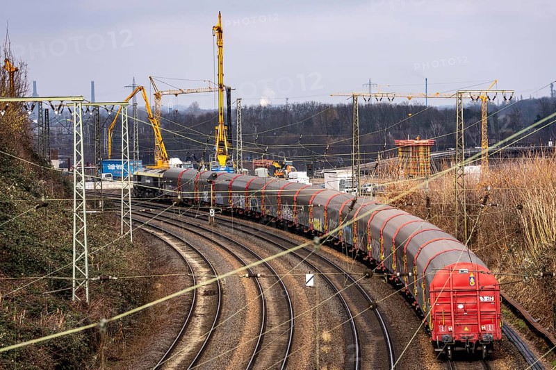 Freight train on the railway line at the Duisburg-Kaiserberg motorway junction, constricted lanes, heavy traffic, complete conversion and construction of the A3 and A40 intersections, all bridges, ramps, roadways are renewed and partly extended, 8-year construction period, railway bridges running there will also be renewed, North Rhine-Westphalia, Germany