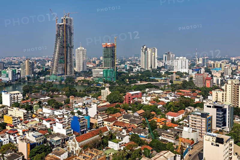 Diverse skyline of a big city with high-rise buildings and construction cranes under clear skies