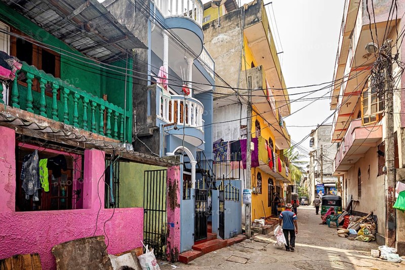 Colourful residential buildings on a busy urban street with passers-by
