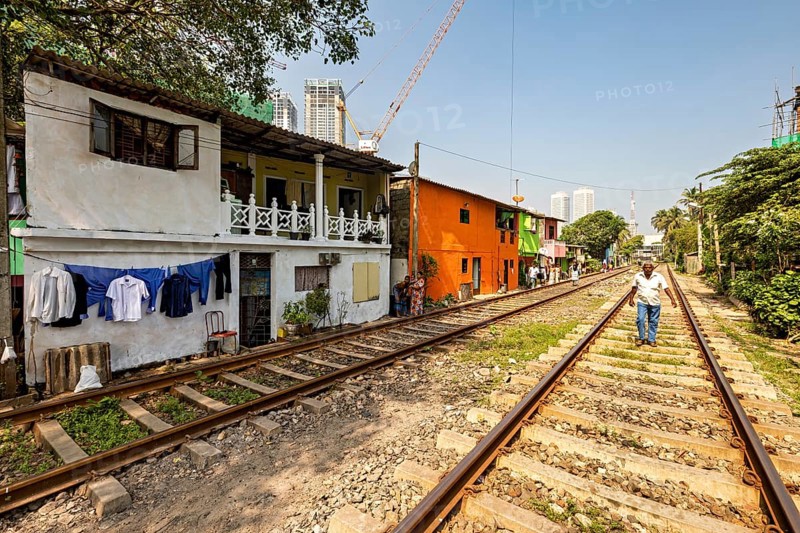 Colourful houses with laundry lines along railroad tracks in an urban setting