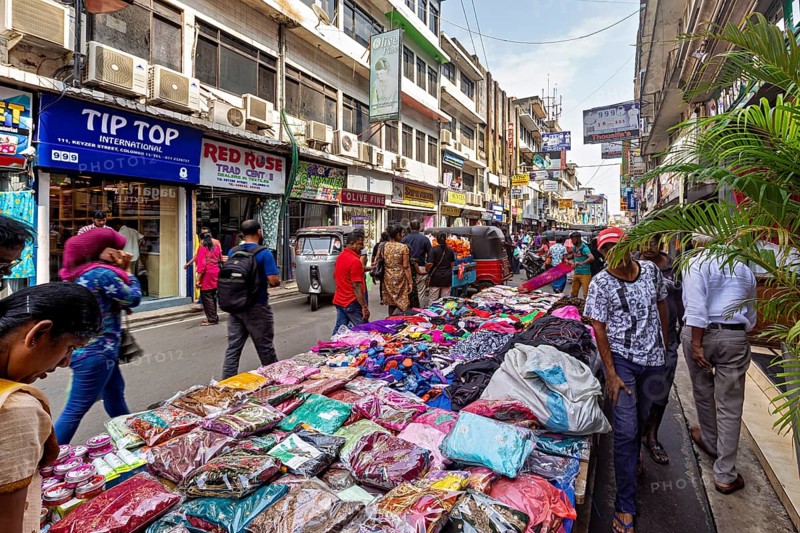 Street market with laid-out clothes and busy foot traffic, the hustle and bustle of Colombo city center in Sri Lanka