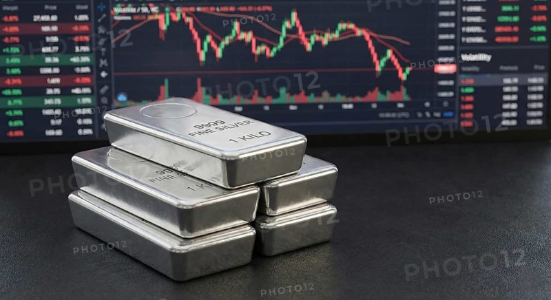 Stacked 99.99% fine silver bars are displayed in front of a digital financial chart, symbolising precious metals trading, market fluctuations, and silver as a safe-haven investment asset, AI generated