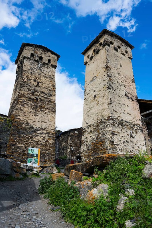 Two old stone towers under a blue sky with clouds, defensive towers, Ushguli, Ushguli, Shibiani district, Zhibiani, Upper Svaneti, Svaneti, Georgia