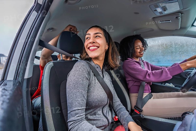 Diverse friends in athletic wear smiling in a car, seatbelts on and ready for a fun pickleball outing or active weekend road trip, excited and bonded together