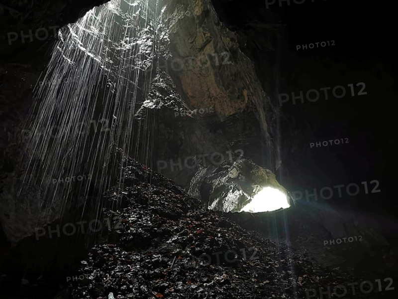 A ray of light falls into a dark cave and awakens a mysterious atmosphere, High Tatras, Poland
