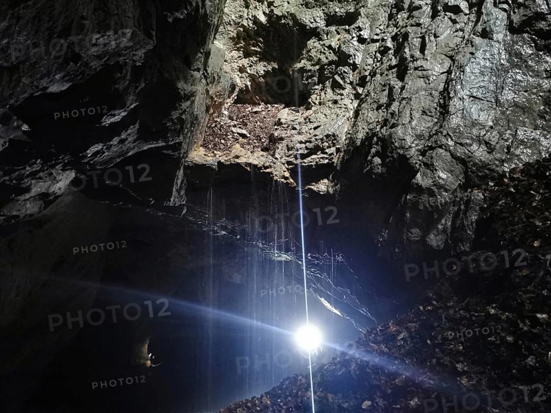 A bright ray of light falls into a dark and mysterious cave, High Tatras, Poland
