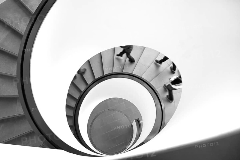 Spiral staircase with descending persons, black and white, Bavaria, Germany