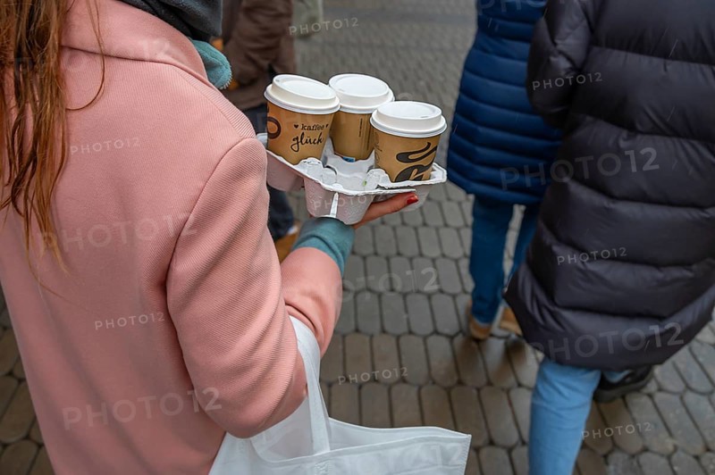 Lady carrying three coffees to go on the street, Nuremberg, Middle Franconia, Bavaria, Germany