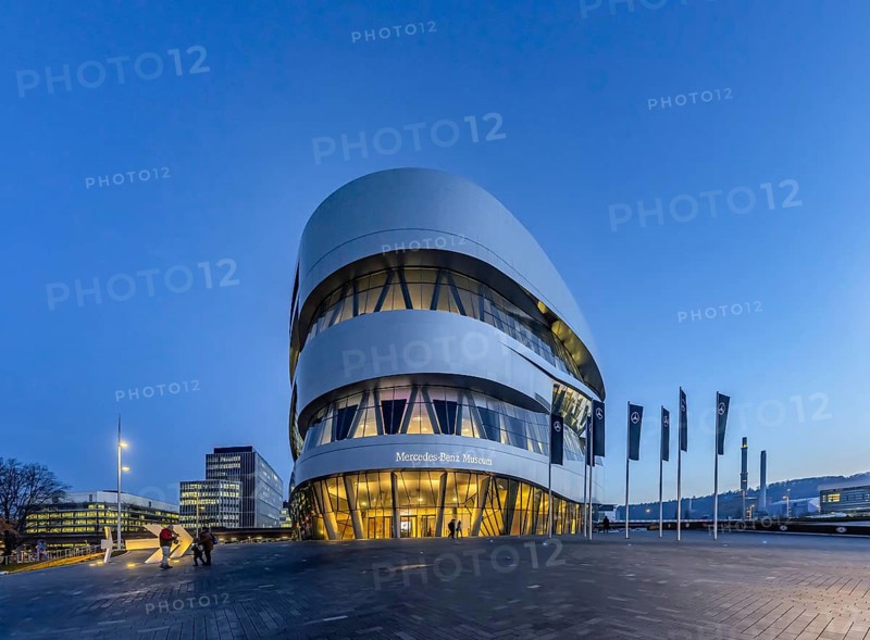 The Mercedes-Benz Museum in Stuttgart presents a journey through the automotive history of the global corporation. Spectacular architecture of the Automobile Museum in the evening. On the left, the headquarters of Mercedes-Benz Group AG. Untertürkheim, Stuttgart, Baden-Württemberg, Germany