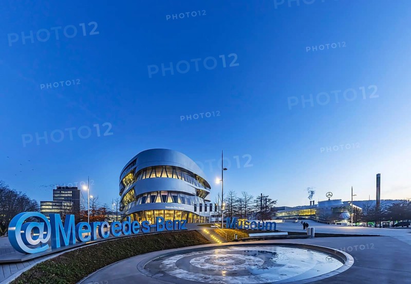 The Mercedes-Benz Museum in Stuttgart presents a journey through the automotive history of the global corporation. Spectacular architecture of the Automobile Museum in the evening. Mercedes-Benz Stuttgart branch on the right. On the left, the headquarters of Mercedes-Benz Group AG. Untertürkheim, Stuttgart, Baden-Württemberg, Germany