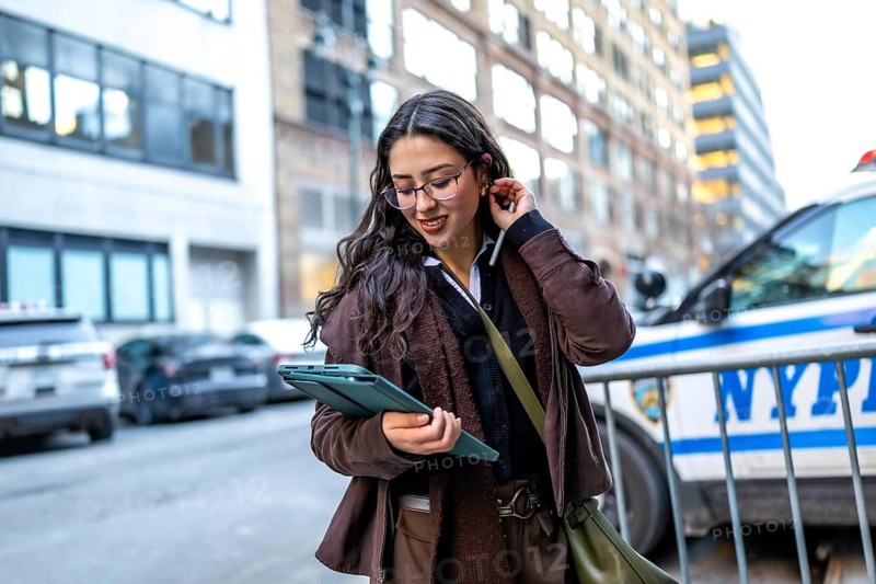 Young businesswoman in glasses walking manhattan streets, focused on her digital tablet while working remotelyconfident, mobile professional blending city life and productivity