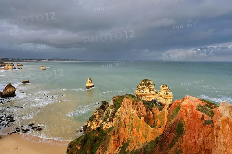 Rocky coast with storm cloud, Praia do Camilo, Lagos, Algarve, Portugal