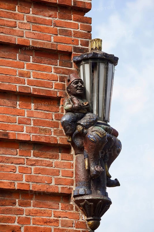 Lantern and sculpture on a house wall, Plön, Holsteinische Schweiz nature park Park, Schleswig-Holstein, Germany