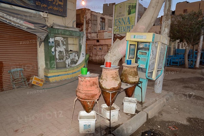 Telephone box and clay carafes with drinking water, Esna, Egypt