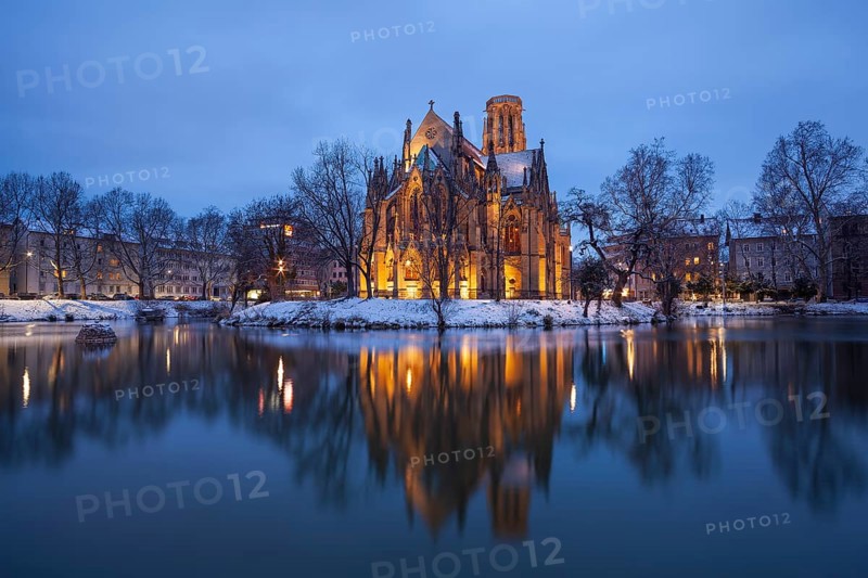 March 18, 2018, winter dusk with snow, illuminated lake and Gothic church Johanneskirche, calm reflections, Feuersee, Stuttgart, Baden-Württemberg, Germany