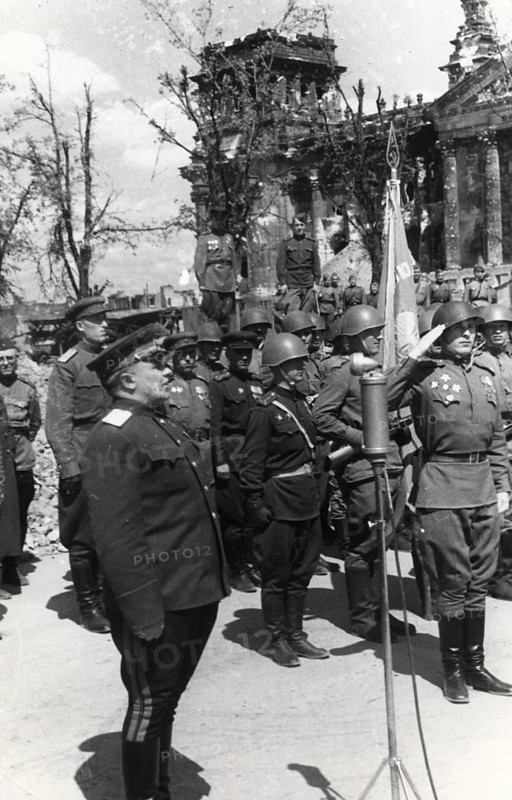 Soviet soldiers salute the destroyed Reichstag in Berlin, Germany, June 1945