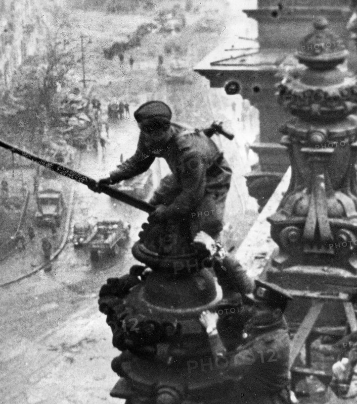 Excerpt from the photo: At the Berlin Reichstag, May 2, 1945, three Soviet soldiers hoist the flag of the Soviet Union. Retouched The watch on the right wrist was scraped out. J. Chaldej took a total of 36 pictures, which he later also changed by adding clouds of smoke, retouching the watch and assembling further variants. The picture became an icon and symbol of the victory over National Socialism