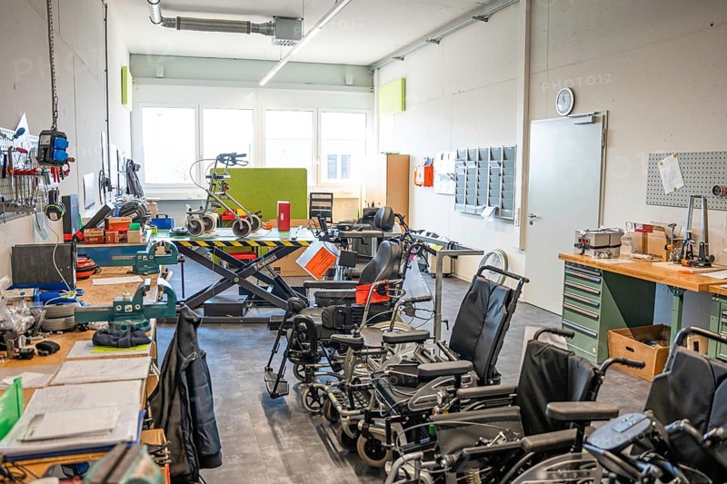 Workshop with wheelchairs and rehabilitation equipment, bright and functional atmosphere, medical supply store