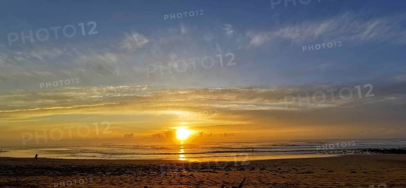 A calm sunset on the beach with cloudy sky and gentle sea, Sidi Ifni, Morocco