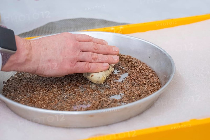 Hands press dough into a round dish with seeds for baking, bake rolls, Haselstaller Hof, Gechingen, Germany