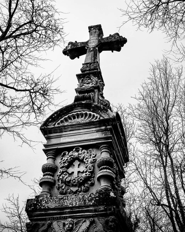 Gothic grave monument with cross in front of bare, wintery trees, black and white photograph, old cemetery, Radolfzell am Lake Constance, district of Konstanz, Baden-Württemberg, Germany