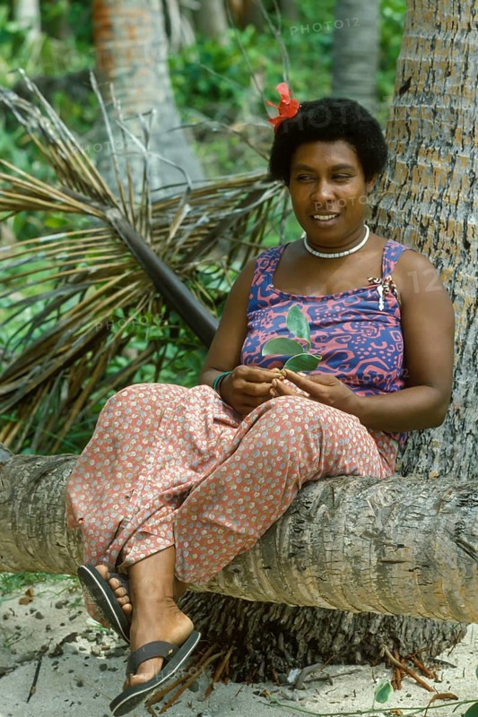 Woman (Katherina) sitting on a coconut trunk on the beach, Tavewa Island, Yasawa Islands, Fiji