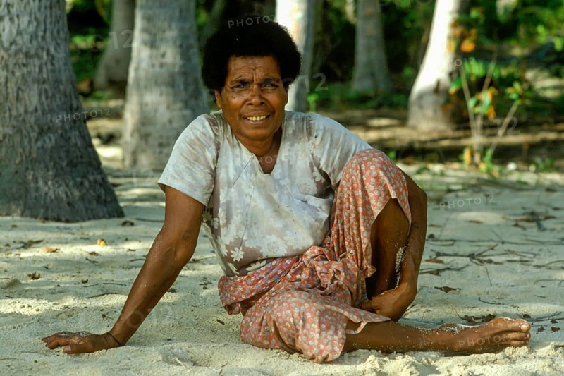 Woman sitting in the sand (there are no chairs on Tavewa) Tavewa Island, Yasawa Islands, Fiji