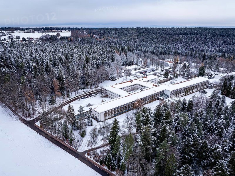 Snowy forest landscape with a large building in the middle, viewed from above, rehab clinic, Schömberg, Black Forest, Germany