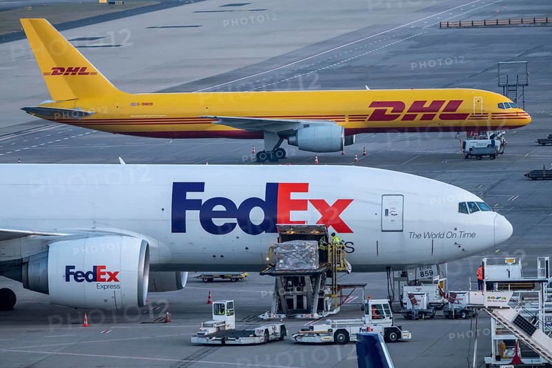 FedEx Express Boeing 777-FS2 cargo aircraft air freight containers are unloaded, DHL Boeing 757-200 at the air freight center at Cologne/Bonn airport, North Rhine-Westphalia, Germany