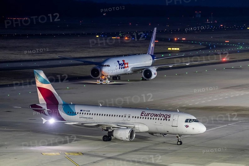 FedEx Boeing 777-FS2 cargo plane is towed to take off, at Cologne/Bonn airport, Eurowings aircraft on the taxiway to the terminal, North Rhine-Westphalia, Germany