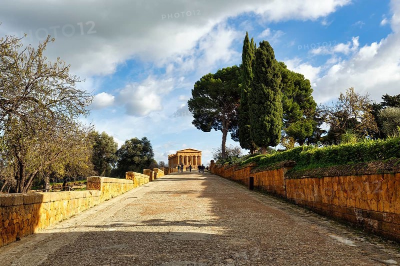 Walkers in front of Concordia Temple, Valley of the Temples, Agrigento, Sicily, Italy
